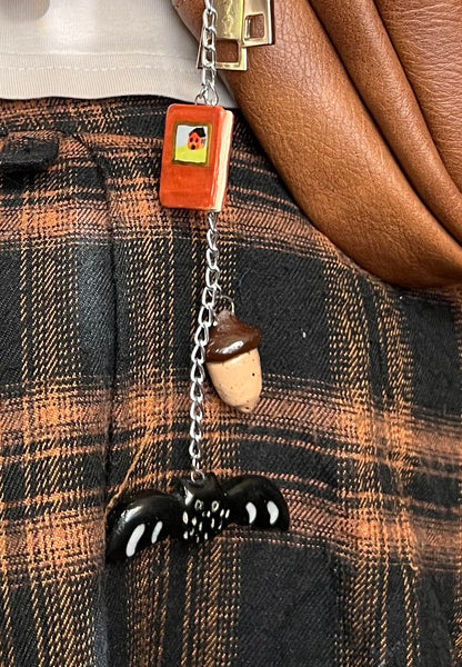 Autumn ceramic bag charm with book, bat, and acorn
