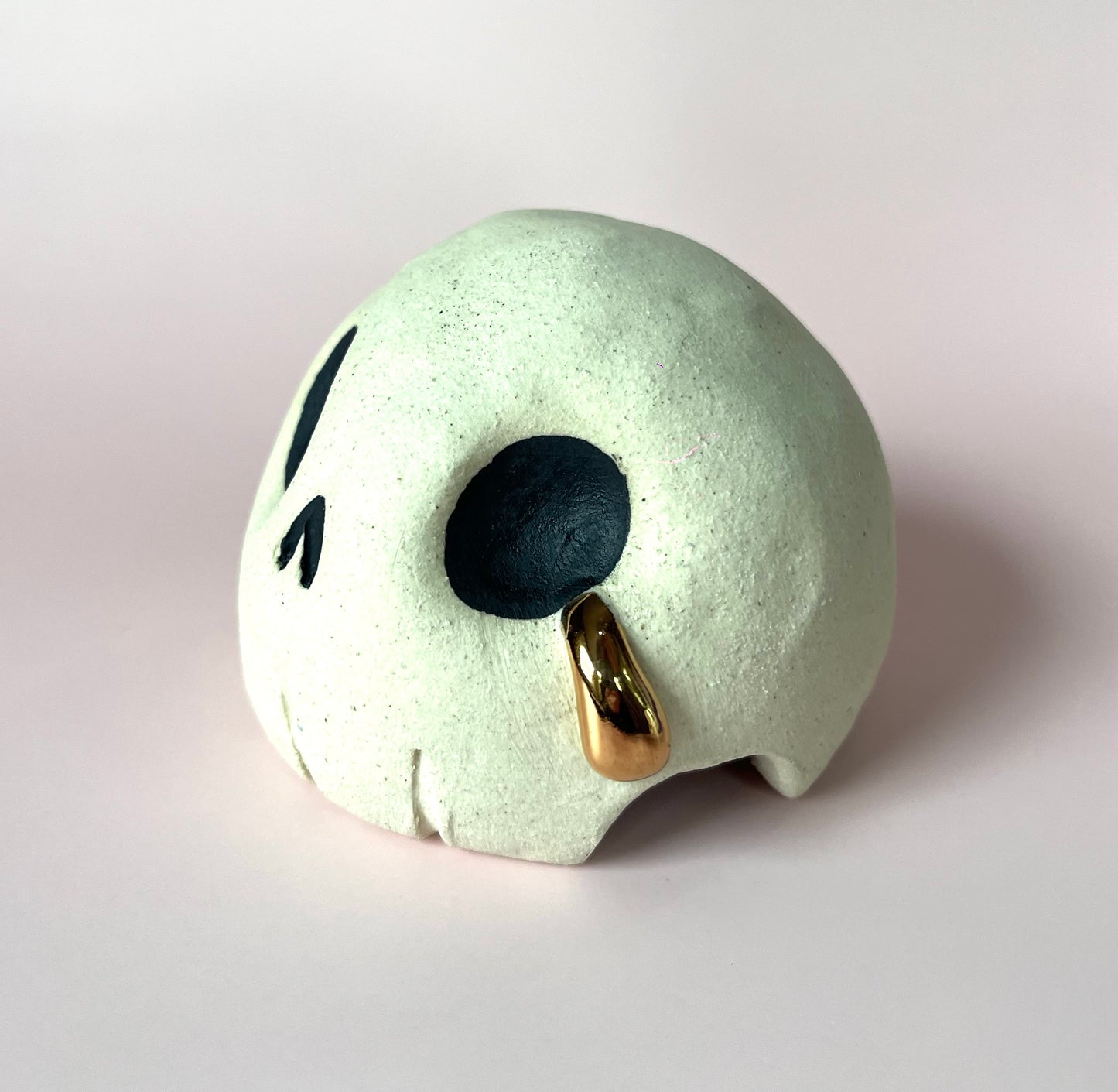 Ceramic skull crying a single tear of gold