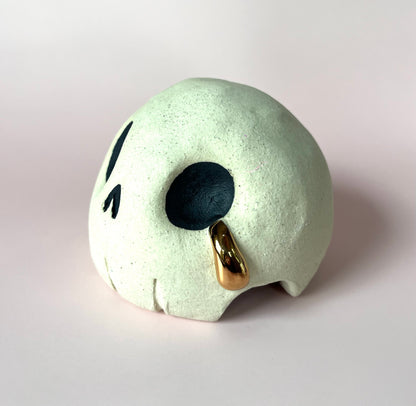 Ceramic skull crying a single tear of gold