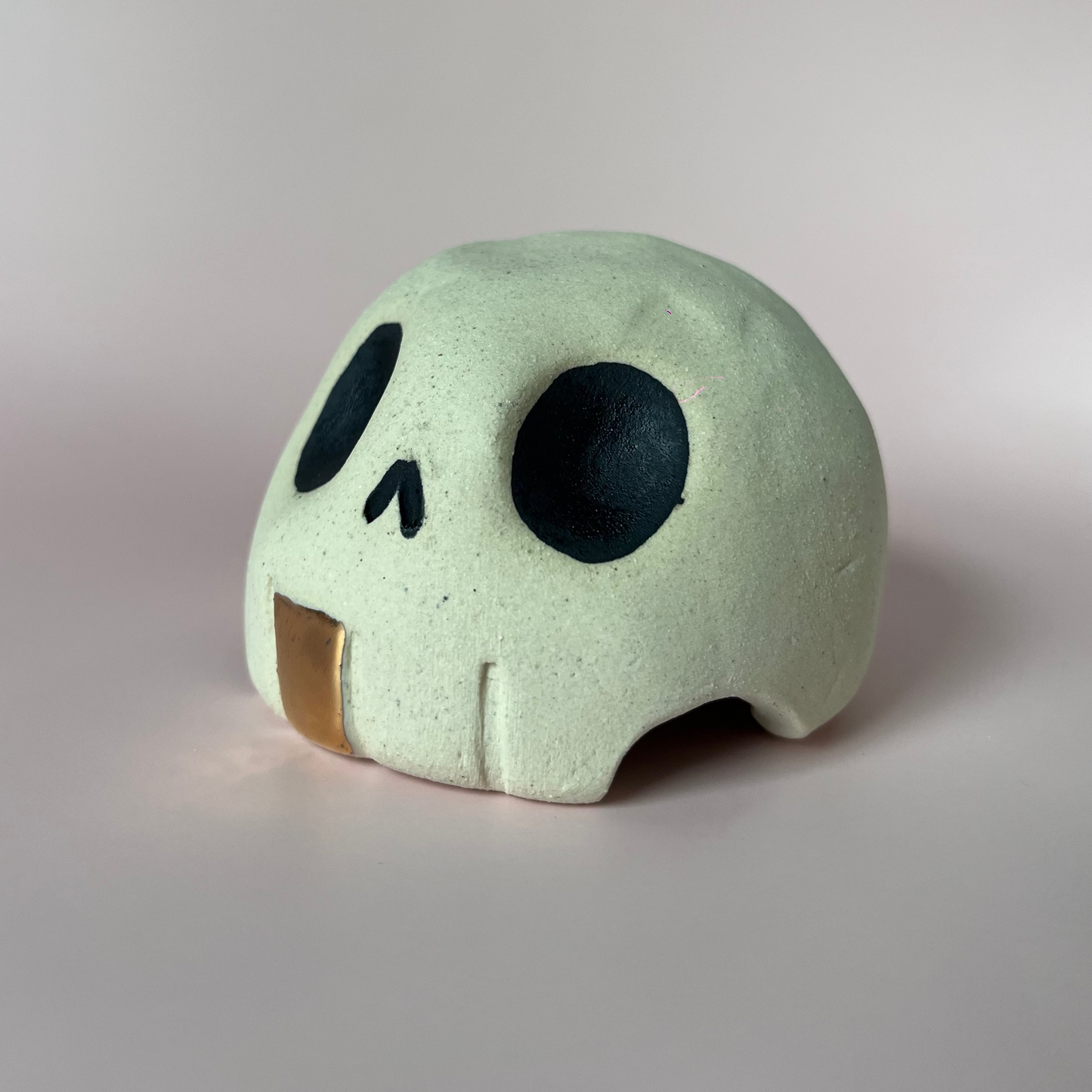 Ceramic skull with a gold toof